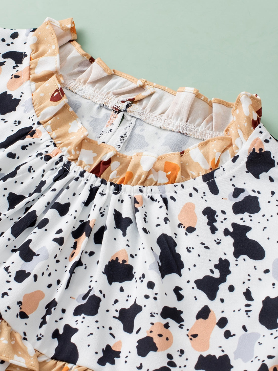 Ruffled Printed Mock Neck Cap Sleeve Blouse